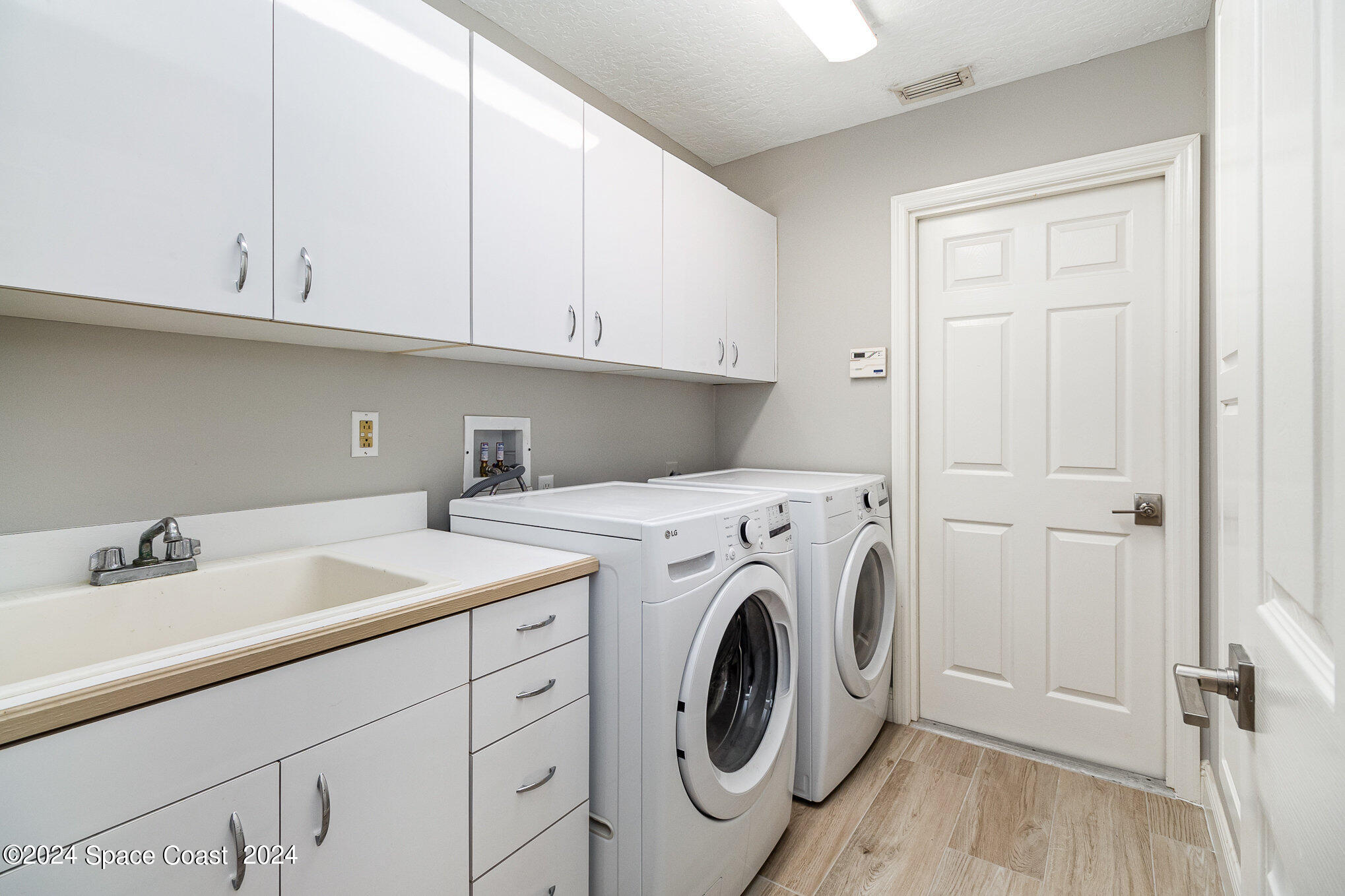 697 Spring Lake Drive Melbourne, FL 32940 - Photo 30 of 51 a utility room with sink dryer and washer