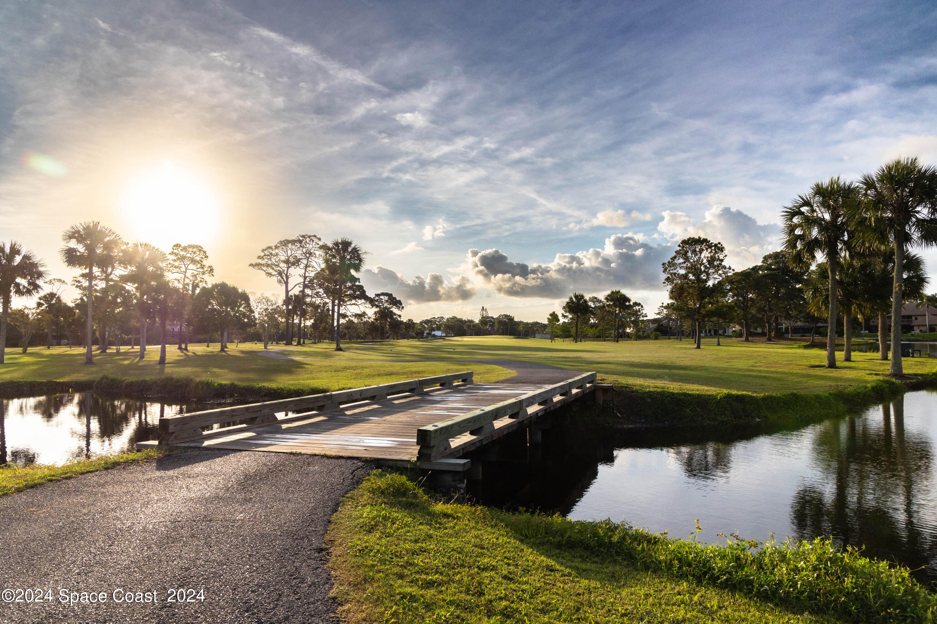 697 Spring Lake Drive Melbourne, FL 32940 - Photo 48 of 51 a view of a lake with a yard and large trees