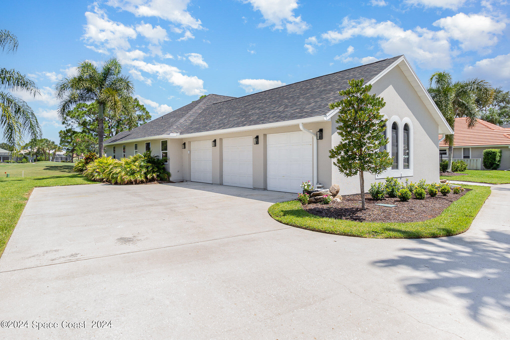 697 Spring Lake Drive Melbourne, FL 32940 - Photo 5 of 51 a front view of a house with a yard and garage