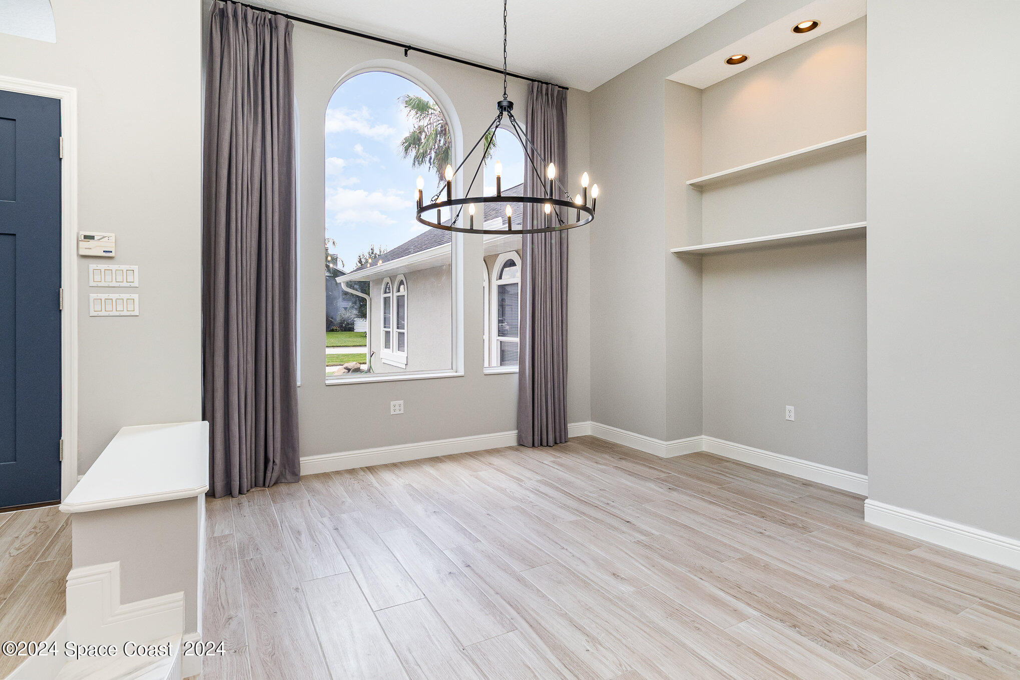 697 Spring Lake Drive Melbourne, FL 32940 - Photo 7 of 51 a view of an empty room with a window and wooden floor