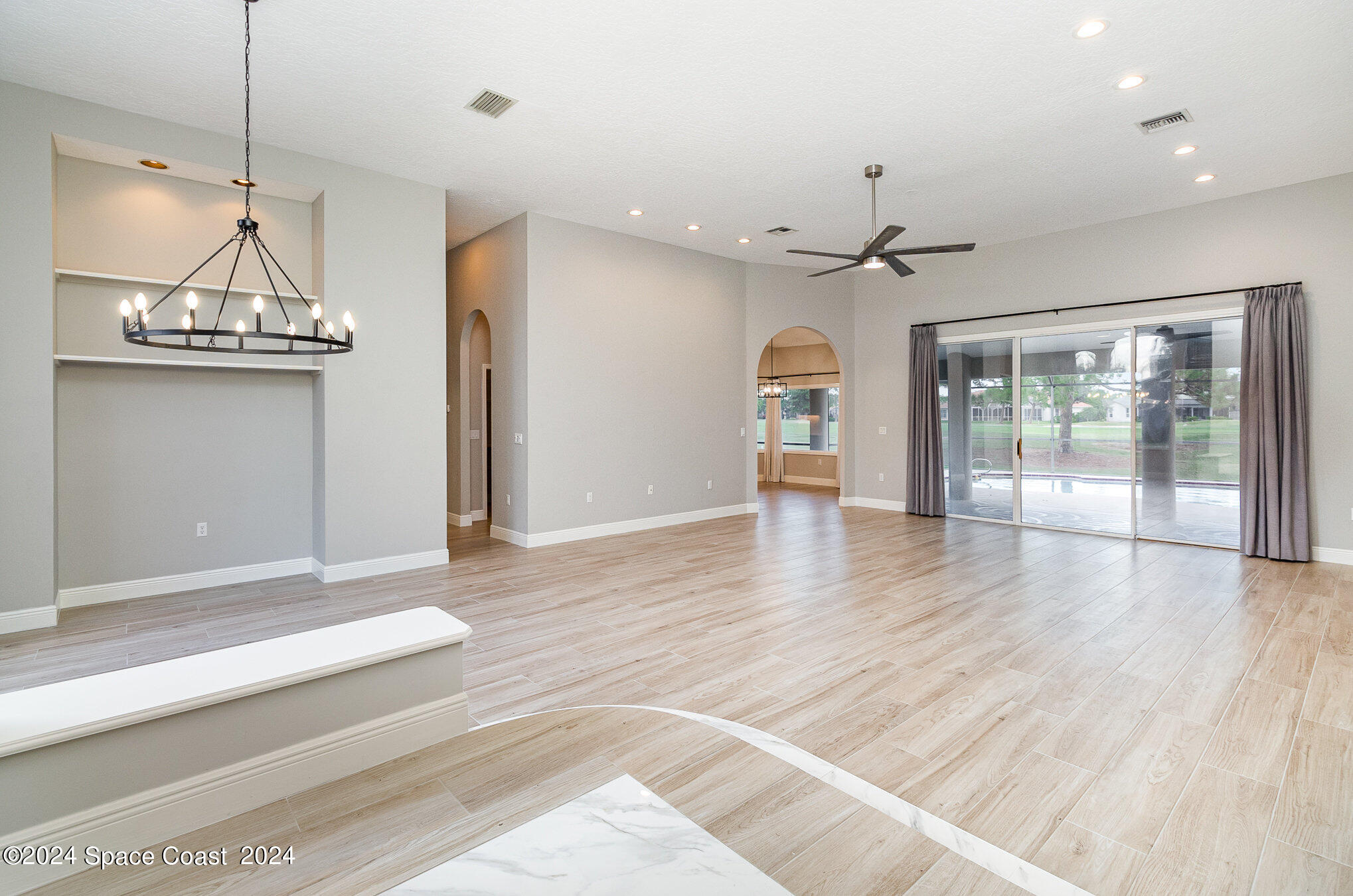 697 Spring Lake Drive Melbourne, FL 32940 - Photo 8 of 51 a view of an empty room with wooden floor and a window