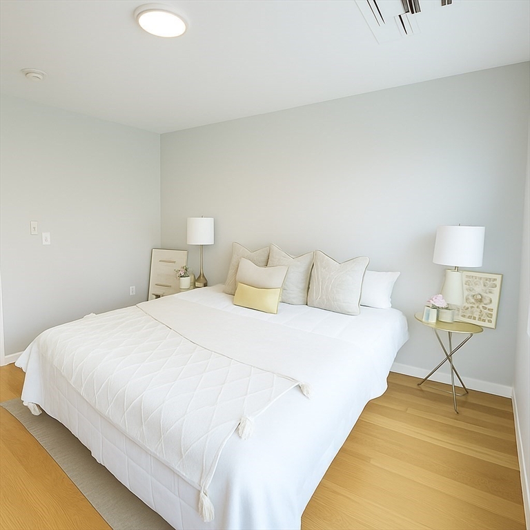 98 Prescott Street, Unit 2C Boston, MA 02128 - Photo 7 of 15 a large bed sitting in a bedroom and a table