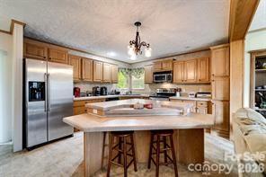 179 Fresh Water Rdg Road Whittier, NC 28789 - Photo 15 of 48 a kitchen with stainless steel appliances granite countertop a sink a stove a refrigerator cabinets and chairs