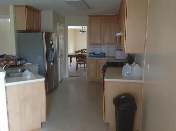 a kitchen with a refrigerator sink and cabinets