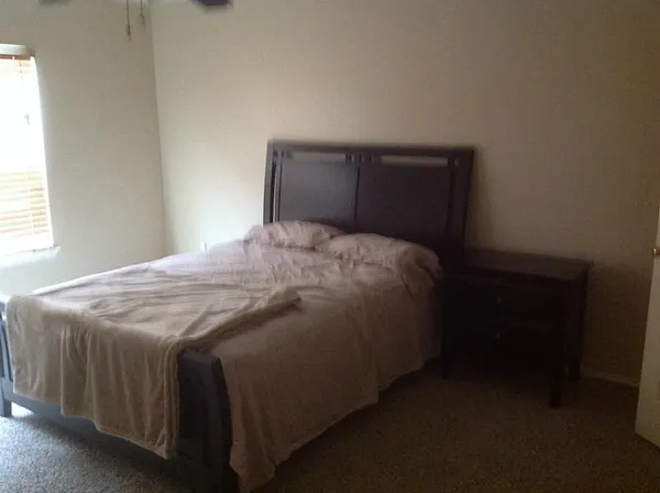 a bed sitting in a bedroom next to a window