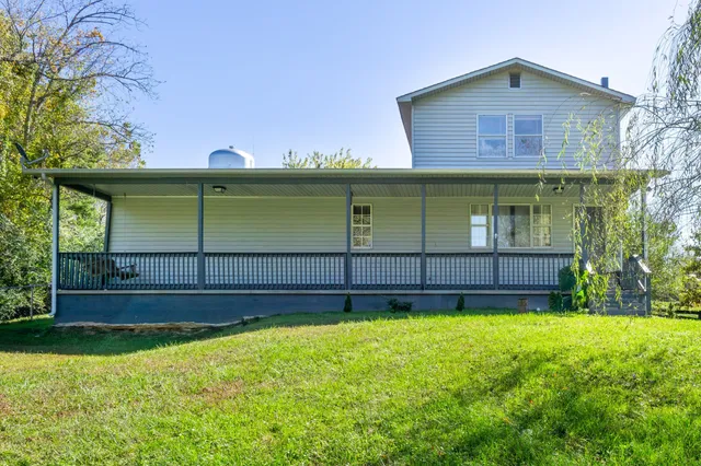 a view of a house with a yard and sitting area