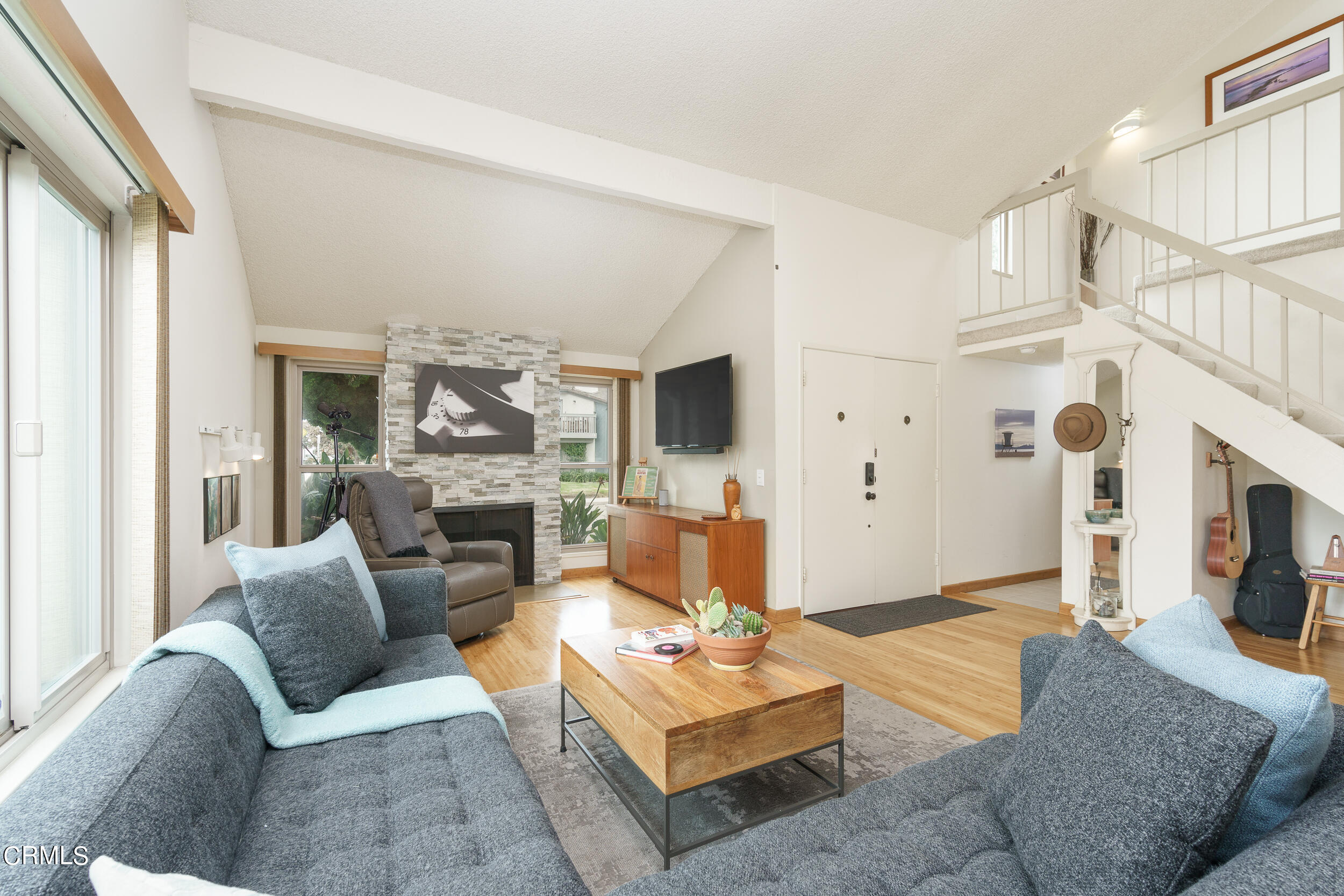 a living room with furniture a fireplace and a flat screen tv
