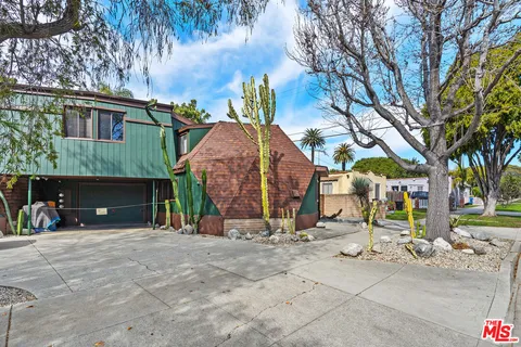 a view of a house with backyard and trees