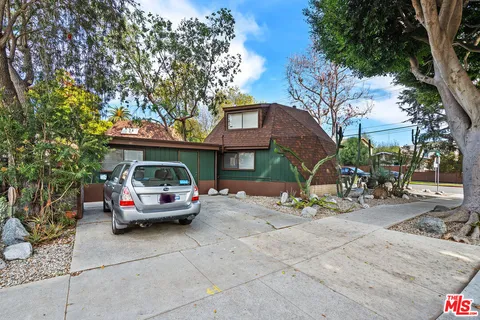 an aerial view of a house with a yard and a large tree