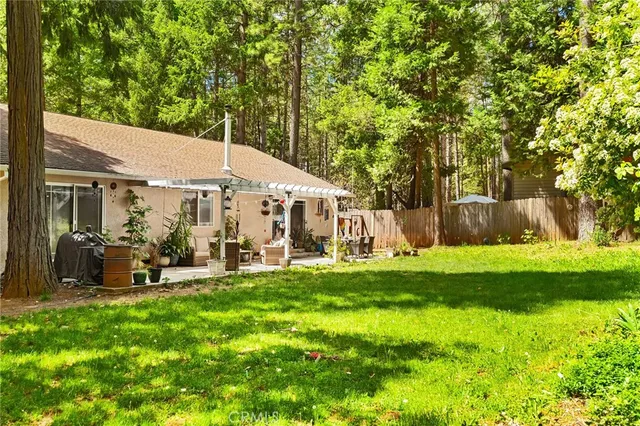 a view of house with backyard and sitting area