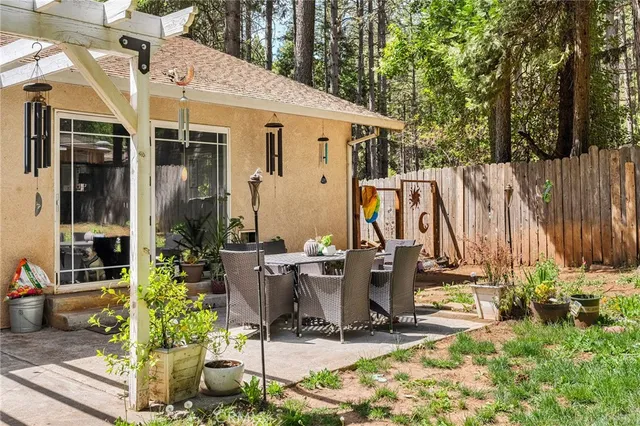 a view of a backyard with wooden fence and flowers