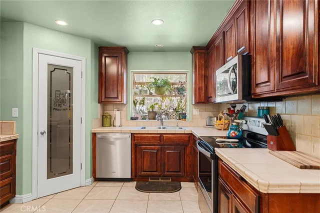 a kitchen with stainless steel appliances granite countertop a sink stove refrigerator and cabinets