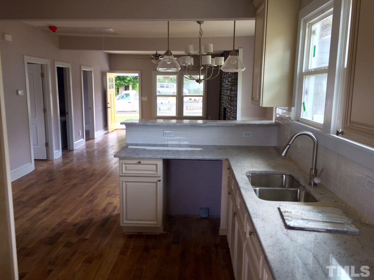 401 Bledsoe Avenue Raleigh, NC 27601 - Photo 2 of 5 a kitchen with kitchen island granite countertop a sink a counter space appliances and cabinets