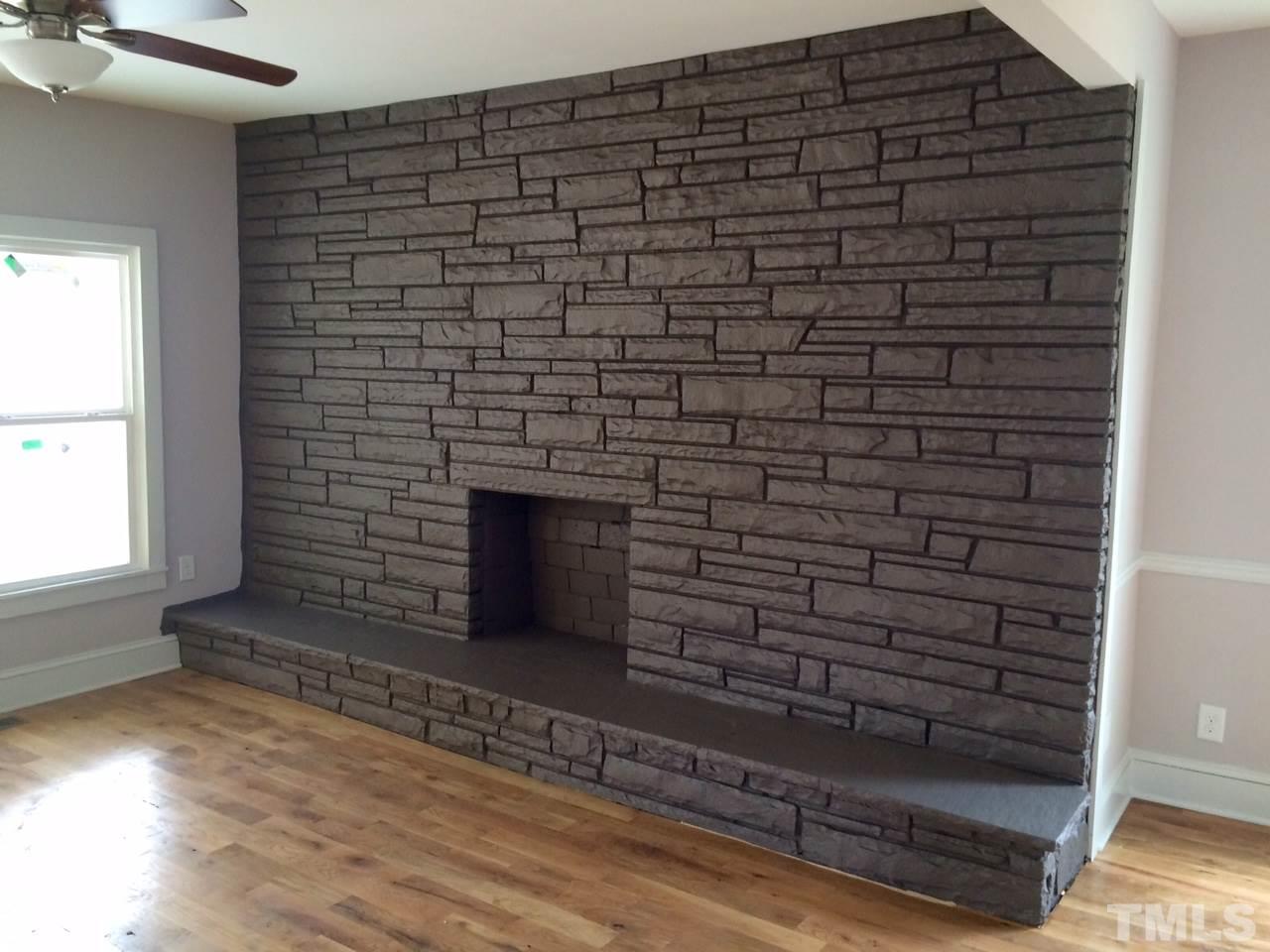 401 Bledsoe Avenue Raleigh, NC 27601 - Photo 4 of 5 a view of an empty room with wooden floor and a fireplace