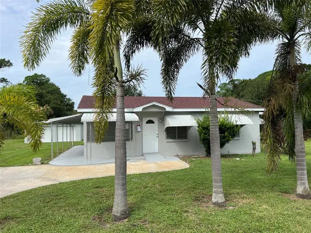 a front view of house with yard and palm tree