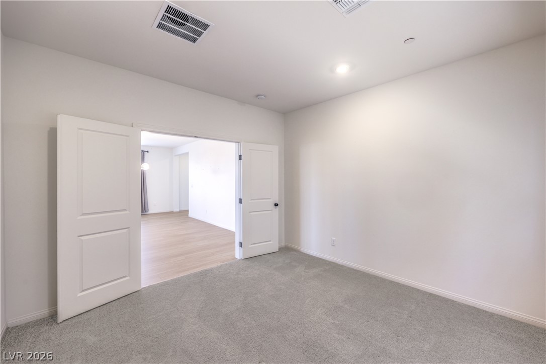 3782 Alla Rocca Avenue Henderson, NV 89044 - Photo 16 of 55 Bright, spacious room featuring carpet flooring and double doors for versatile living.