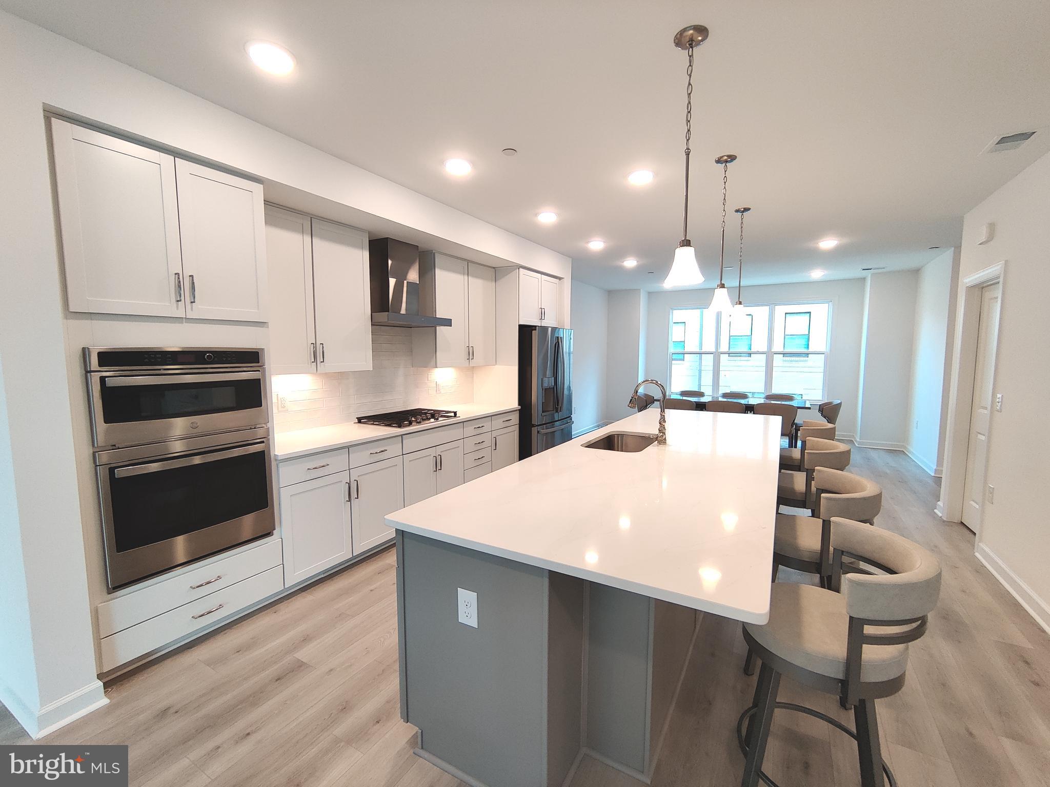 5002 Longmire Way, Unit 70 Chantilly, VA 20151 - Photo 5 of 28 a large kitchen with kitchen island white cabinets and stainless steel appliances