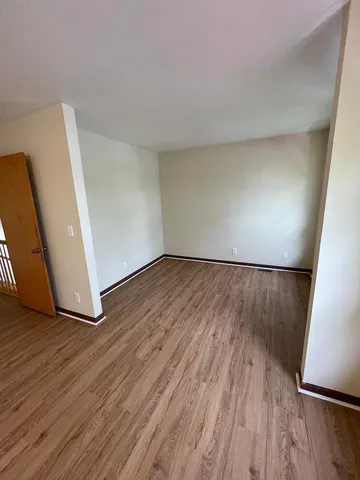 an empty room with wooden floor and entrance