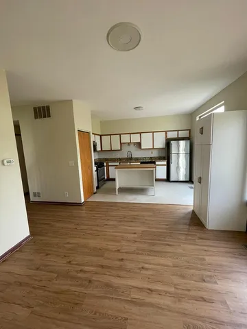 a view of a room with wooden floor and furniture