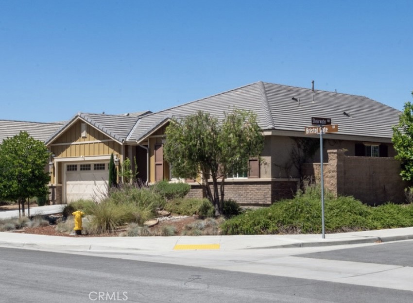 30237 Bristol Gate Lane Menifee, CA 92584 - Photo 1 of 34 a front view of a house with a yard and potted plants