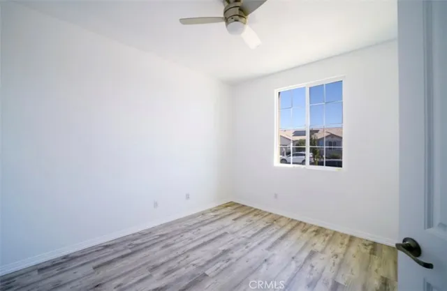 a view of a room with wooden floor and white walls