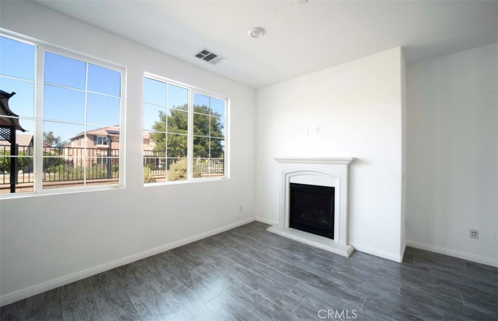 30237 Bristol Gate Lane Menifee, CA 92584 - Photo 18 of 34 a view of an empty room with wooden floor and a window
