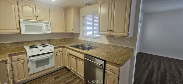 a kitchen with granite countertop a sink stove and cabinets