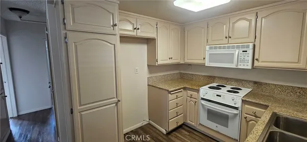 a kitchen with white cabinets and white appliances