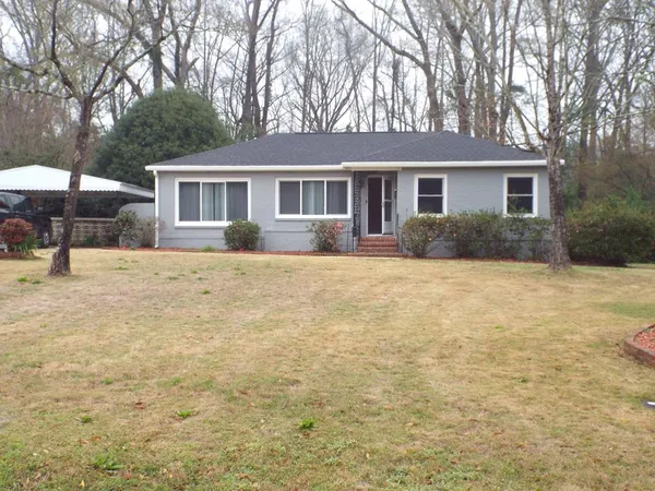 a front view of a house with a yard and trees