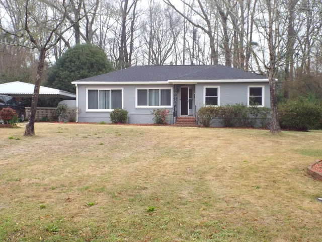a front view of a house with a yard and trees