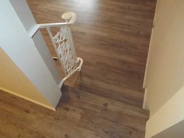 an empty room with a chandelier fan and windows