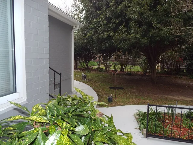 a view of a roof deck with wooden fence and trees