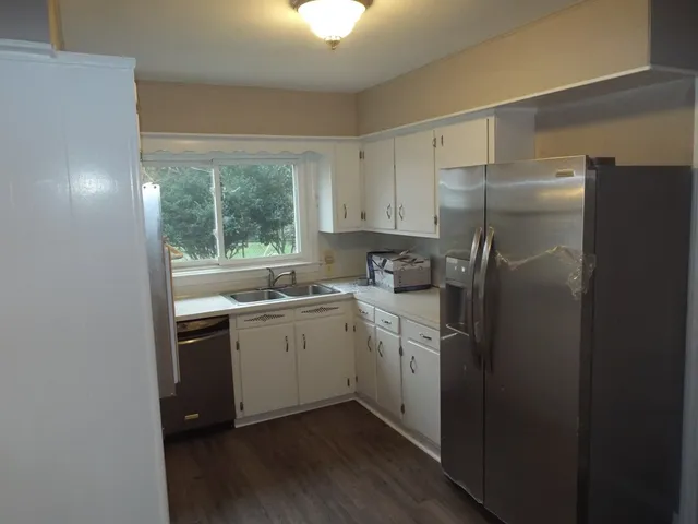 a kitchen with a refrigerator sink and window