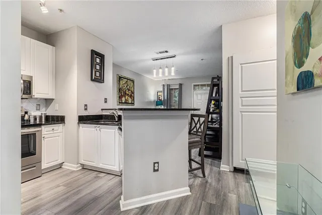 a kitchen with cabinets and wooden floor