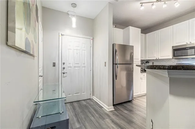 a kitchen with stainless steel appliances granite countertop a refrigerator and a stove