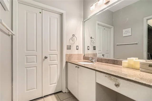 a bathroom with a granite countertop sink and a mirror