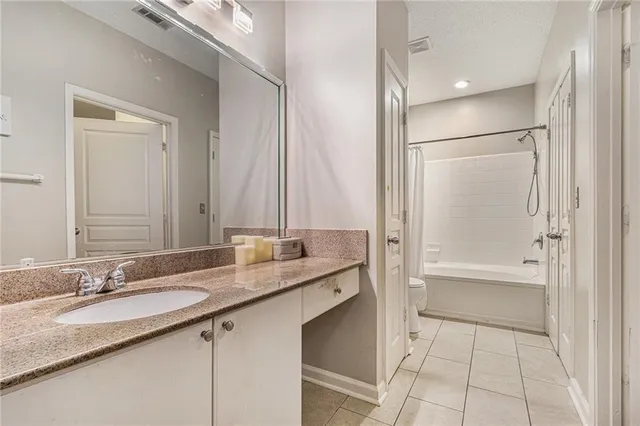 a bathroom with a granite countertop sink mirror and a bathtub