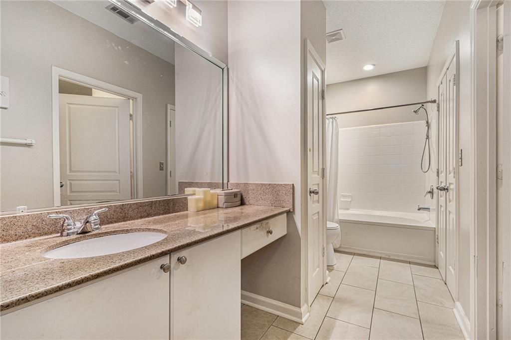 10 Perimeter Summit Boulevard, Unit 4131 Atlanta, GA 30319 - Photo 28 of 30 a bathroom with a granite countertop sink mirror and a bathtub