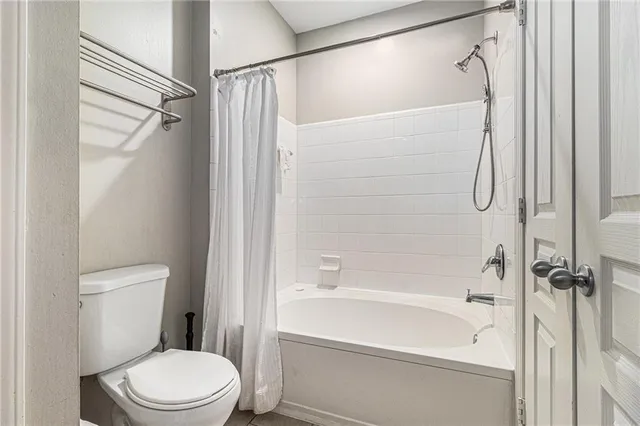 a white toilet sitting next to a bath tub