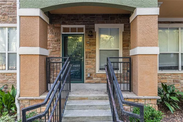 a front view of a house with glass windows and furniture