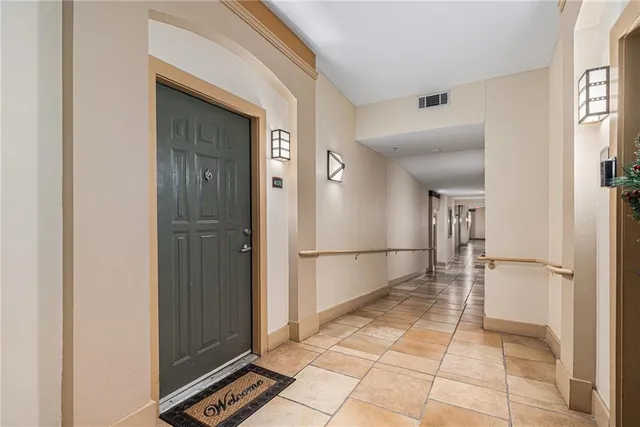 a view of a refrigerator in kitchen and an empty room