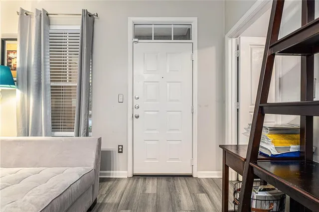 a living room with a bed and a flat tv screen on dresser