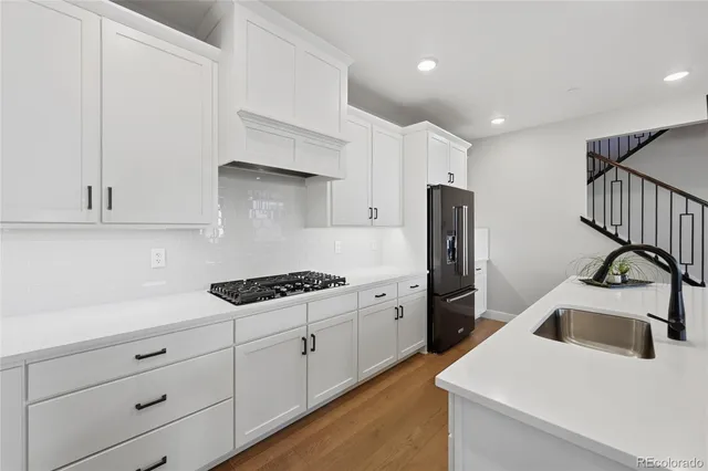 a kitchen with stainless steel appliances granite countertop a sink a stove and a refrigerator