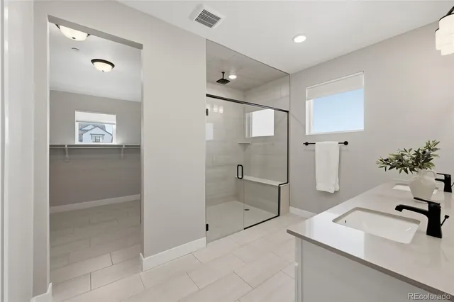 a bathroom with a sink shower and a mirror