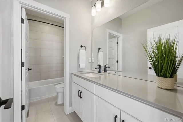 a bathroom with a granite countertop sink a toilet and a bathtub
