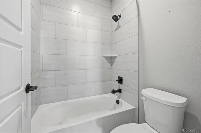 a white bath tub sitting next to a toilet