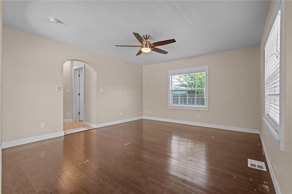 222 25th Street North St. Petersburg, FL 33713 - Photo 12 of 32 an empty room with wooden floor ceiling fan and windows