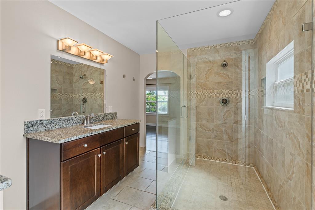 222 25th Street North St. Petersburg, FL 33713 - Photo 23 of 32 a bathroom with a granite countertop sink a shower and a mirror
