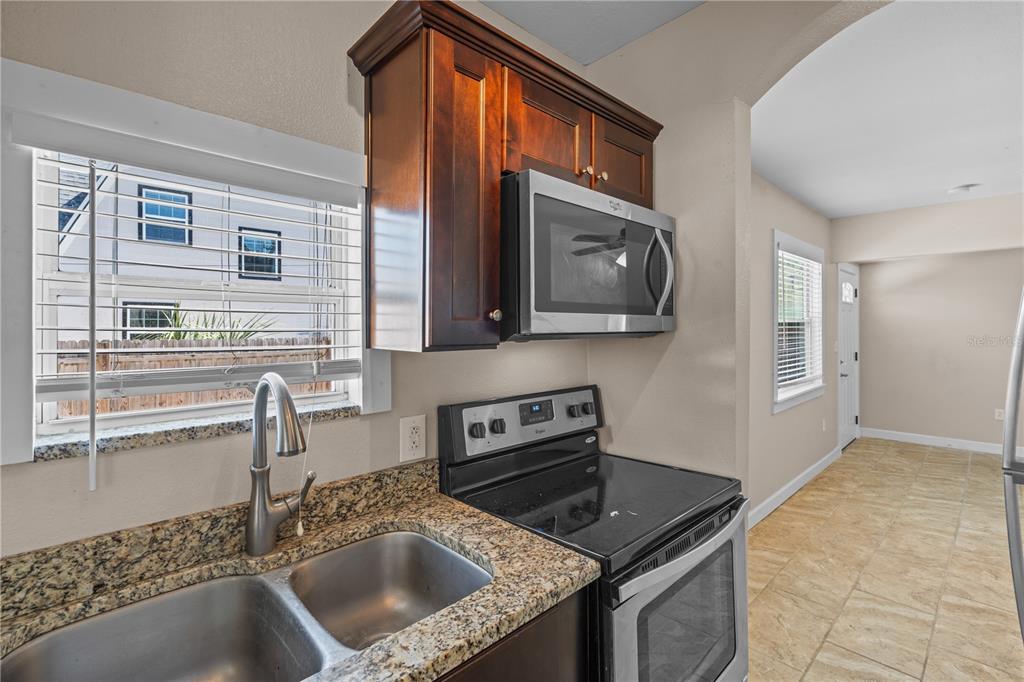 222 25th Street North St. Petersburg, FL 33713 - Photo 28 of 32 a kitchen with granite countertop a sink a stove and cabinets