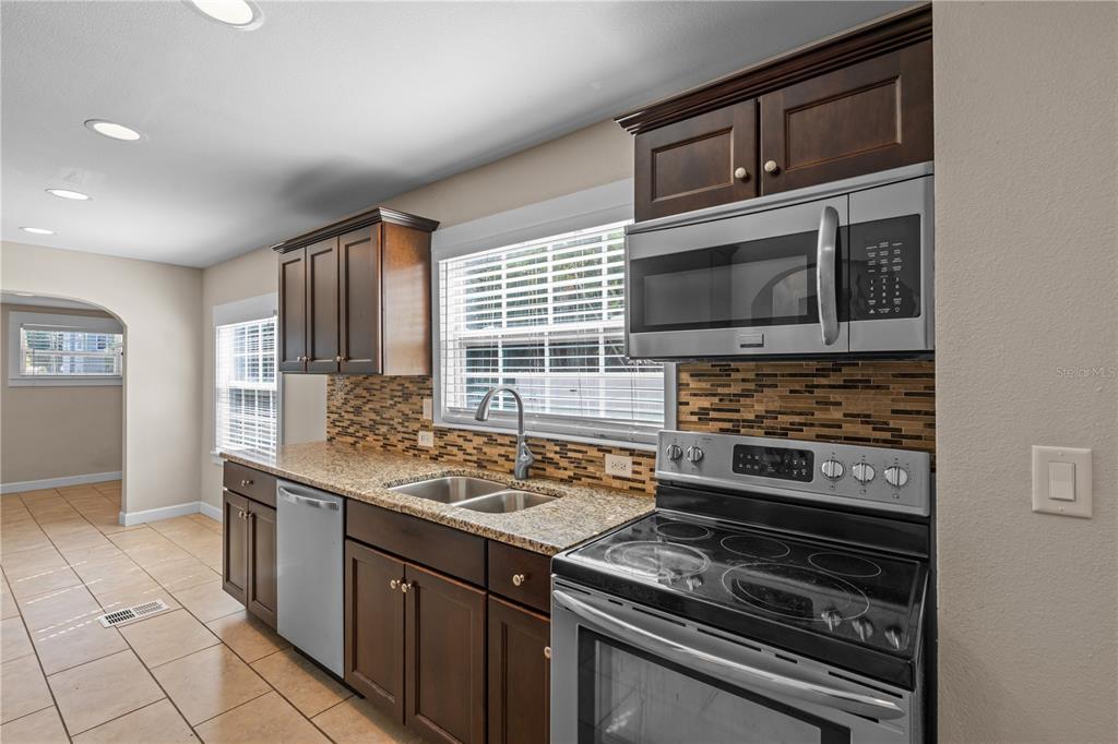 222 25th Street North St. Petersburg, FL 33713 - Photo 8 of 32 a kitchen with stainless steel appliances granite countertop a stove microwave and refrigerator